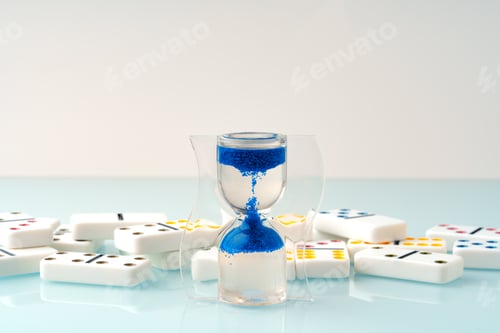 Preview: Hourglass and domino tiles on blue background. Time limit concept