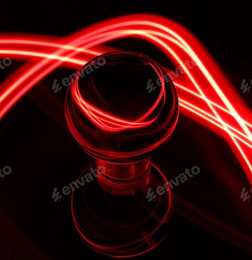 Preview: Intriguing red light emanating from a light bulb in a dimly lit setting