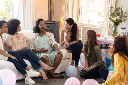 Preview: African American woman surrounded by friends celebrating baby shower at home
