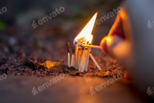 Preview: Person's hand lighting a Mini Bonfire out the backyard with matches with bright flame and fire.