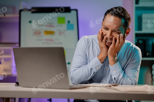 Preview: Asian man showing a scared expression in the office, company employee working overtime, working late