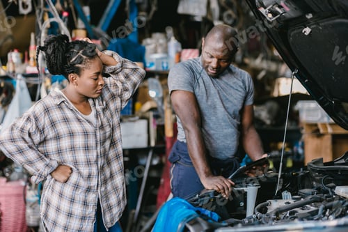 Woman and Man Working on Car in Garage