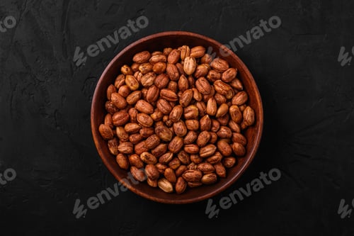 Preview: Hazelnuts in wooden bowl on dark background