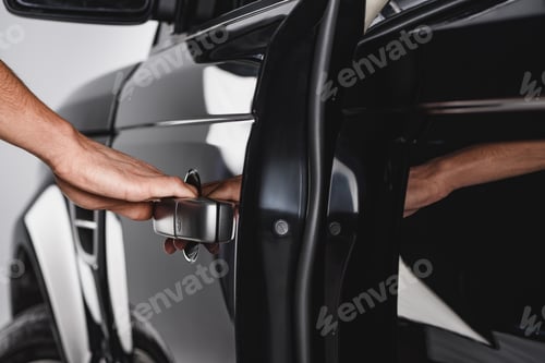 Preview: partial view of man holding card door handle