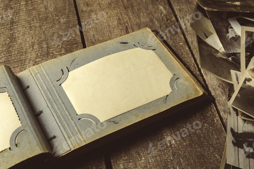 Preview: Old photo album with empty spaces for memories on wooden surface