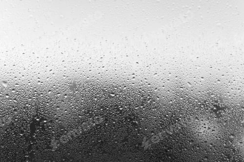 Preview: Condensation drop on glass, close-up. Black and white defocused backdrop