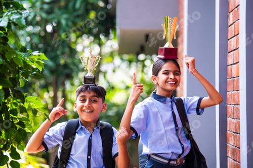 Preview: Indian School Kids in Uniform Flaunting Trophy Proudly While Standing Outside and Looking at Camera