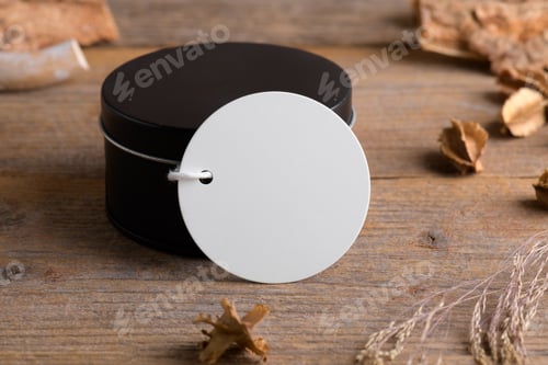 Preview: Round white gift tag mockup on black round box on rustic wooden background with boho decoration