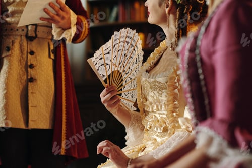 Preview: Caucasian Young Woman Holding Decorative Fan during Baroque Era Gathering