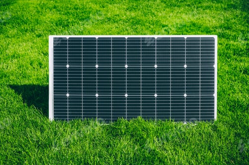 Preview: Solar panel generating renewable energy on green grass in a summer sunny day.