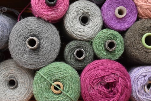 Preview: Closeup of industrial colorful wool reels in the manufacturing room