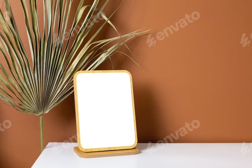 Preview: Wooden frame copyspace and plant on white table with dark orange wall background