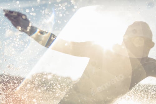 Preview: A swimmer in a wet suit running into the water, making a splash.