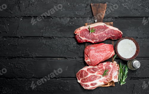 Preview: Raw meat. Pork and beef steaks with salt and spices.