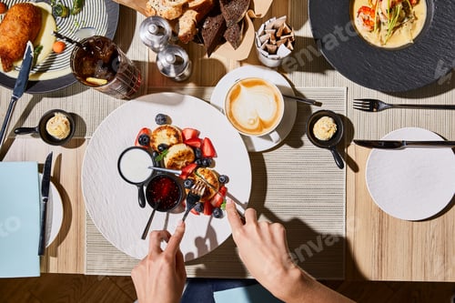 Preview: top view of woman eating delicious syrniki at restaurant