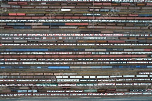 Preview: Aerial view of a train yard with multiple railway lines, with cars on top