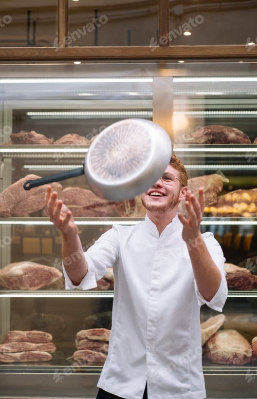 Preview: Chef in jacket with frying pan in air