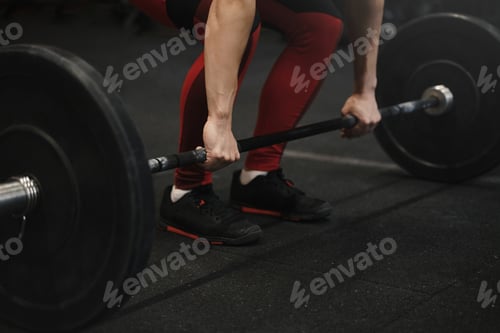 Preview: Closeup of crossfit female athlete preparing for lifting weights at the gym.