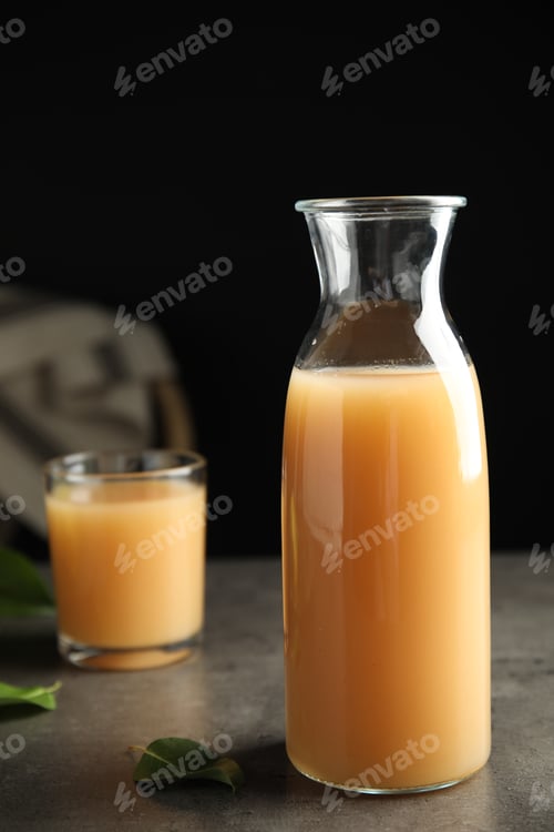 Preview: Fresh pear juice in glass bottle on grey table