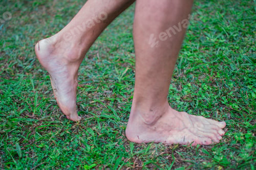 Preview: Man with bare feet moving forward in wet grass