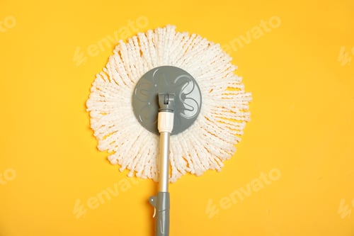 Preview: String mop on yellow background, top view
