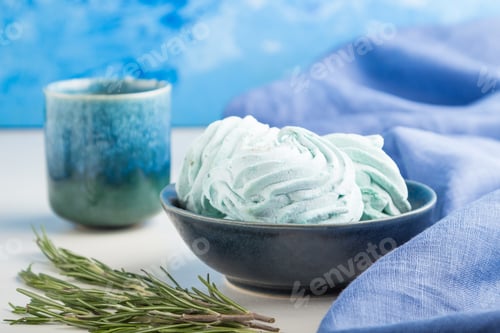 Preview: Blue colored homemade zephyr or marshmallow with cup of coffee on white wooden background