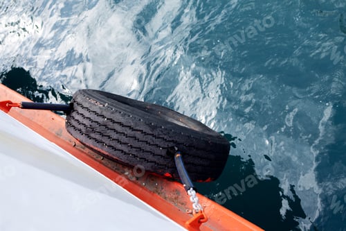 Preview: Web banner 4x1. Mooring tire on board white ferry against background of sea water. View from above