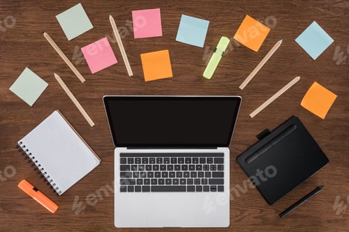 Preview: top view of workplace with arranged textbooks, post it and laptop with blank screen