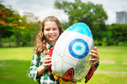 Preview: Portrait of red hair kid in pilot costume holding bolloon running in summer field
