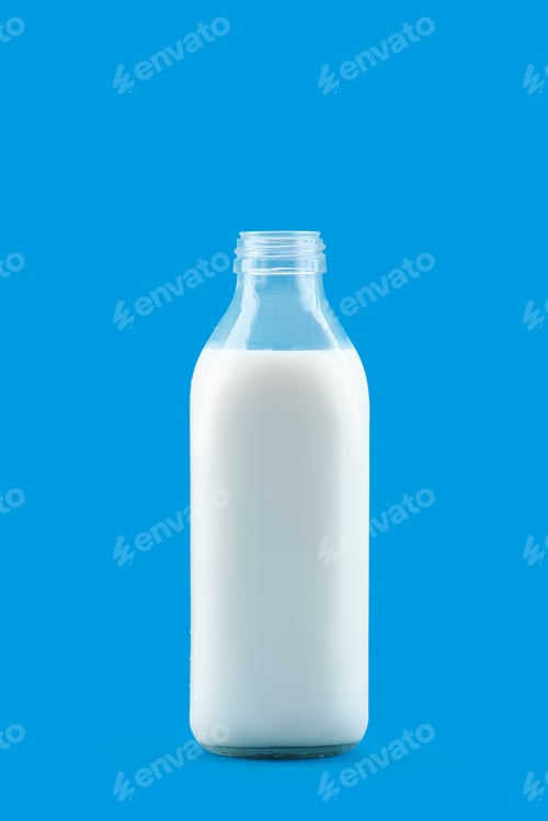 Preview: Open bottle of milk isolated on blue background
