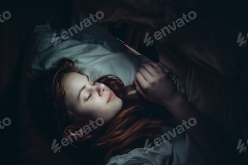 Preview: pretty woman lying in bed at night with phone before bedtime addiction