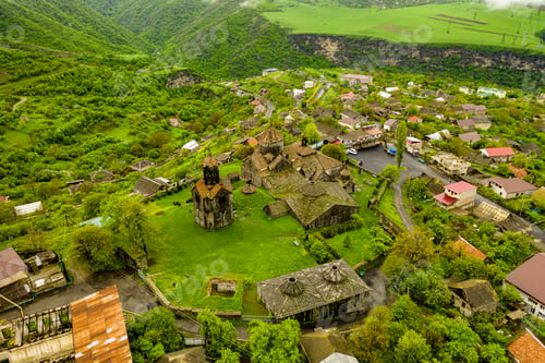 Preview: Aerial view of Haghpat monastery on top of a green hill full of houses in Armenia