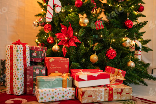 Preview: Beautiful Christmas gift boxes on floor near fir tree in room.