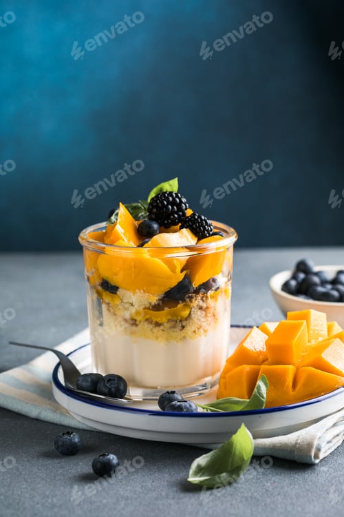Preview: Trifle dessert with berries and cream on wooden table. Copy space