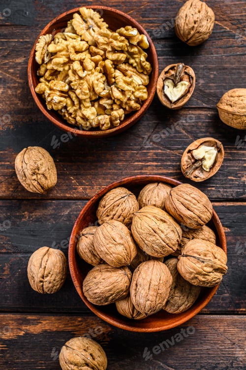 Preview: Shelled walnuts on wooden table. Dark background. Top view
