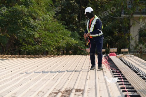Preview: Engineer installing solar cell panels on roof.