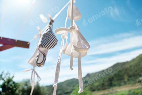 Preview: White woman bikini swimsuit hanging air drying on line in summer sunny windy day.