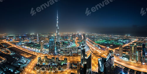 Preview: Cityscape of Dubai, United Arab Emirates at night, with the Burj Khalifa skyscraper in the distance.