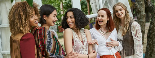 Preview: carefree multiethnic girlfriends in boho outfits talking in modern retreat center, banner