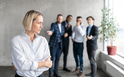 Preview: Male Coworkers Whispering Behind Unhappy Victimized Business Lady In Office