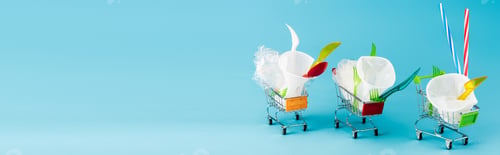 Preview: disposable plastic objects in small shopping carts on blue background, panoramic shot