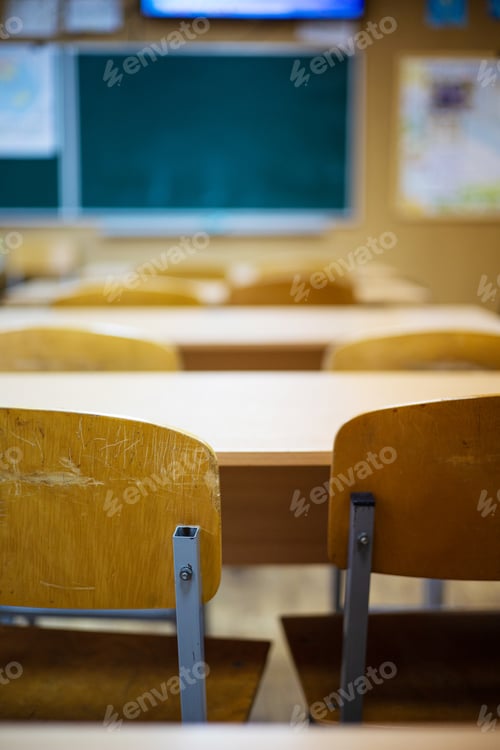 Preview: Classroom with empty chairs and blackboard in the background, shallow depth of field