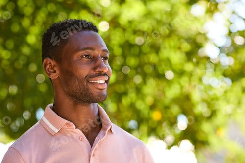 Preview: Head And Shoulders Portrait Of Smiling Man Outside Relaxing In Countryside Looking Off Camera