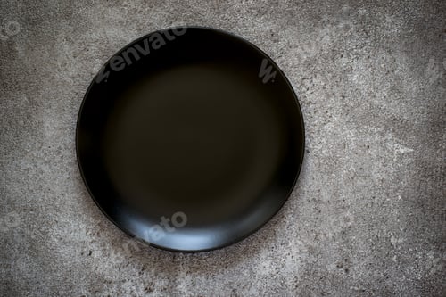 Preview: Empty black ceramic plate On a concrete background. Top view wit