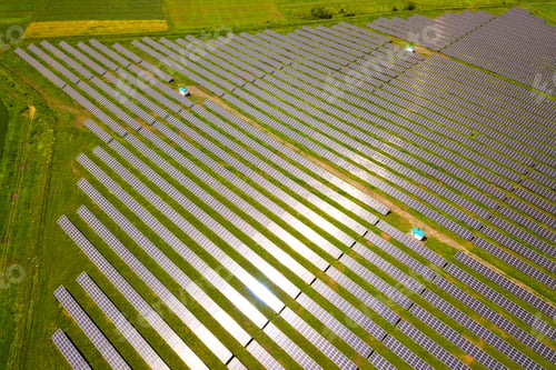 Preview: Aerial view of solar power plant on green field. Electric panels for producing clean ecologic energy