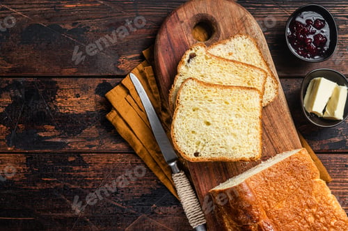 Preview: Brioche bread on breakfast table with butter and jam. Wooden background. Top view. Copy space