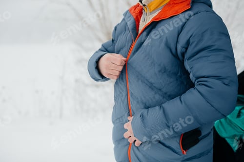 Preview: Person zipping up jacket in winter snow