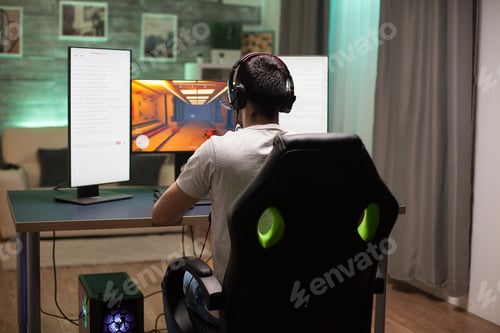Preview: Back view of man sitting on gaming chair