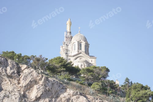 Preview: Low-angle shot the cathedral of Notre dame de lagarde in Marseille, France atop a rocky outcrop