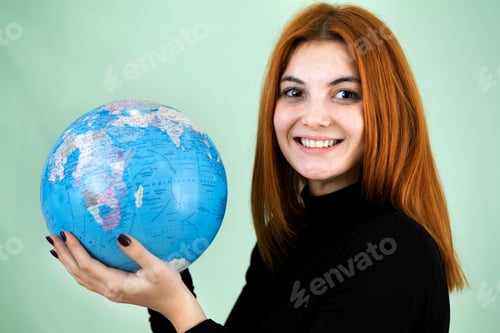 Preview: Portrait of a happy young woman holding geographic globe of the world in her hands.